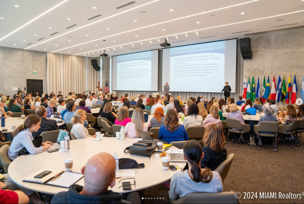 A large group of people in front of a projector screen.