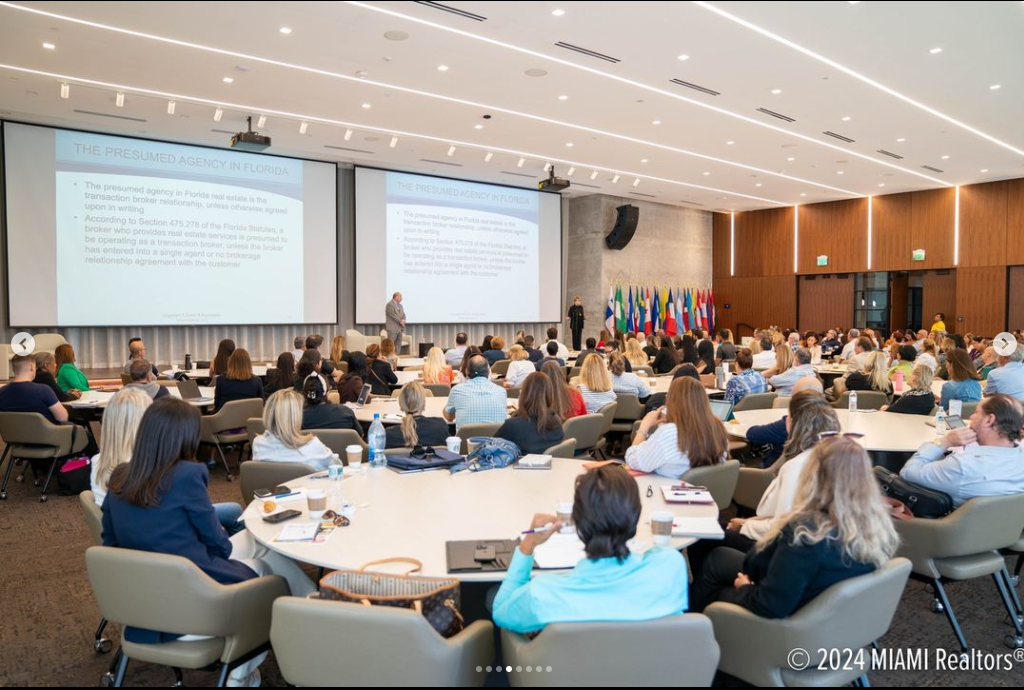 A large group of people in front of a projector screen.